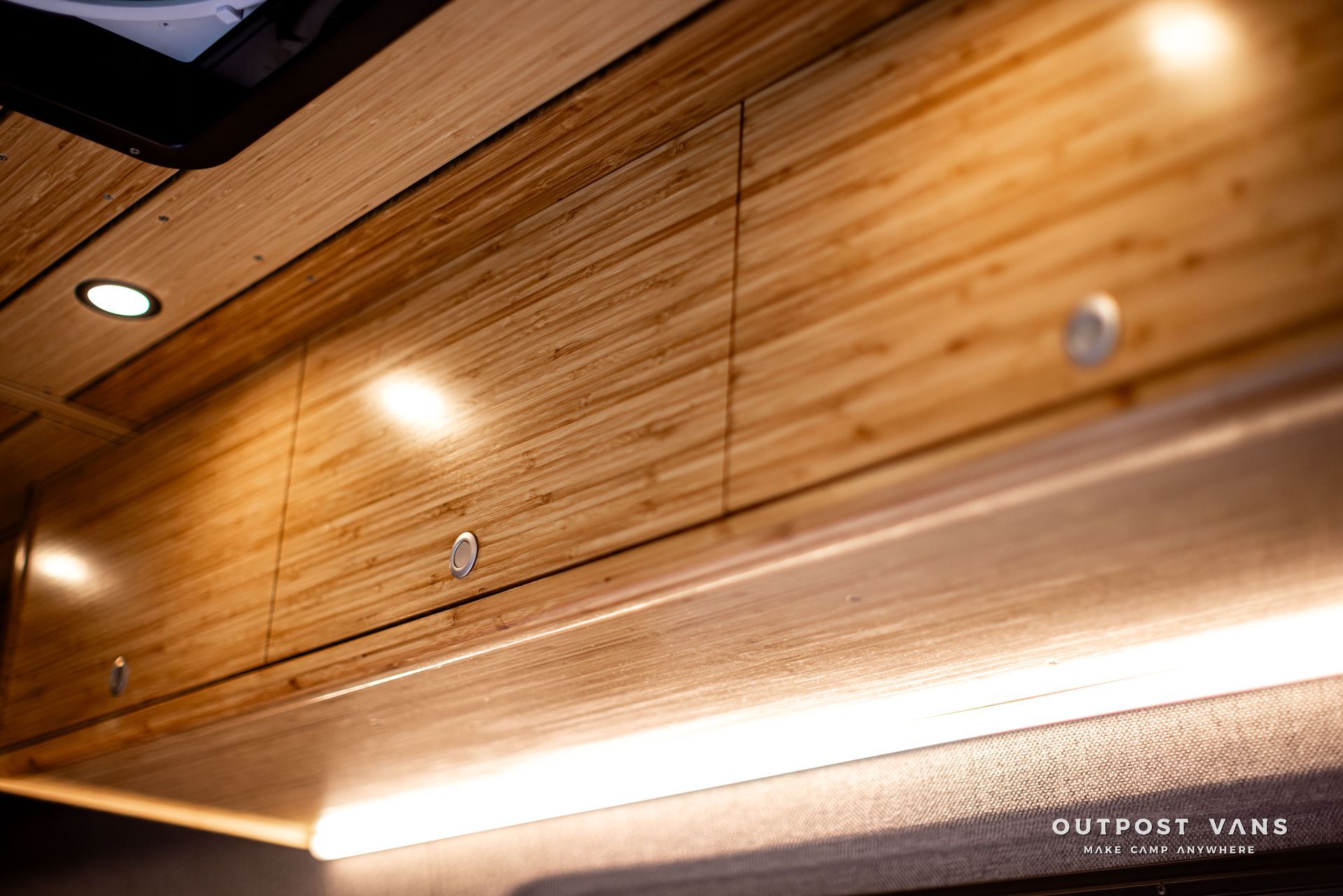 A ceiling with wooden cabinets and a light on it