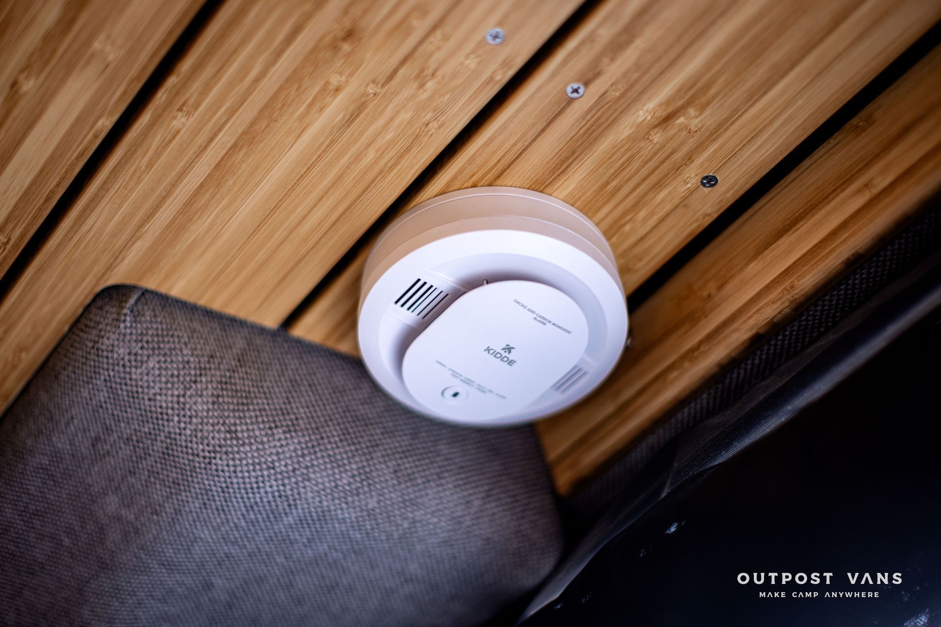 A smoke detector is mounted to the ceiling of a room.