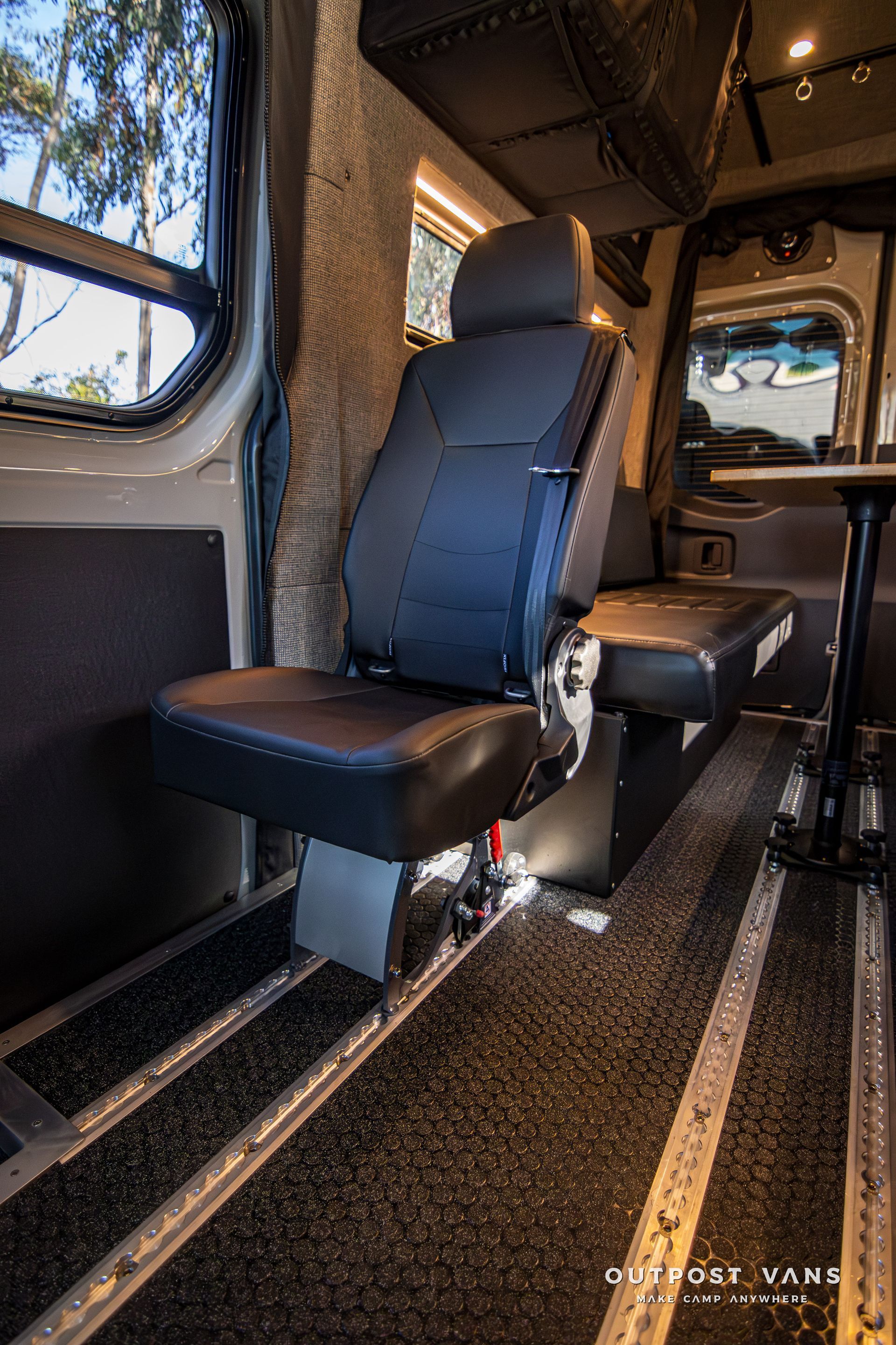 A black leather seat in the back of a van.
