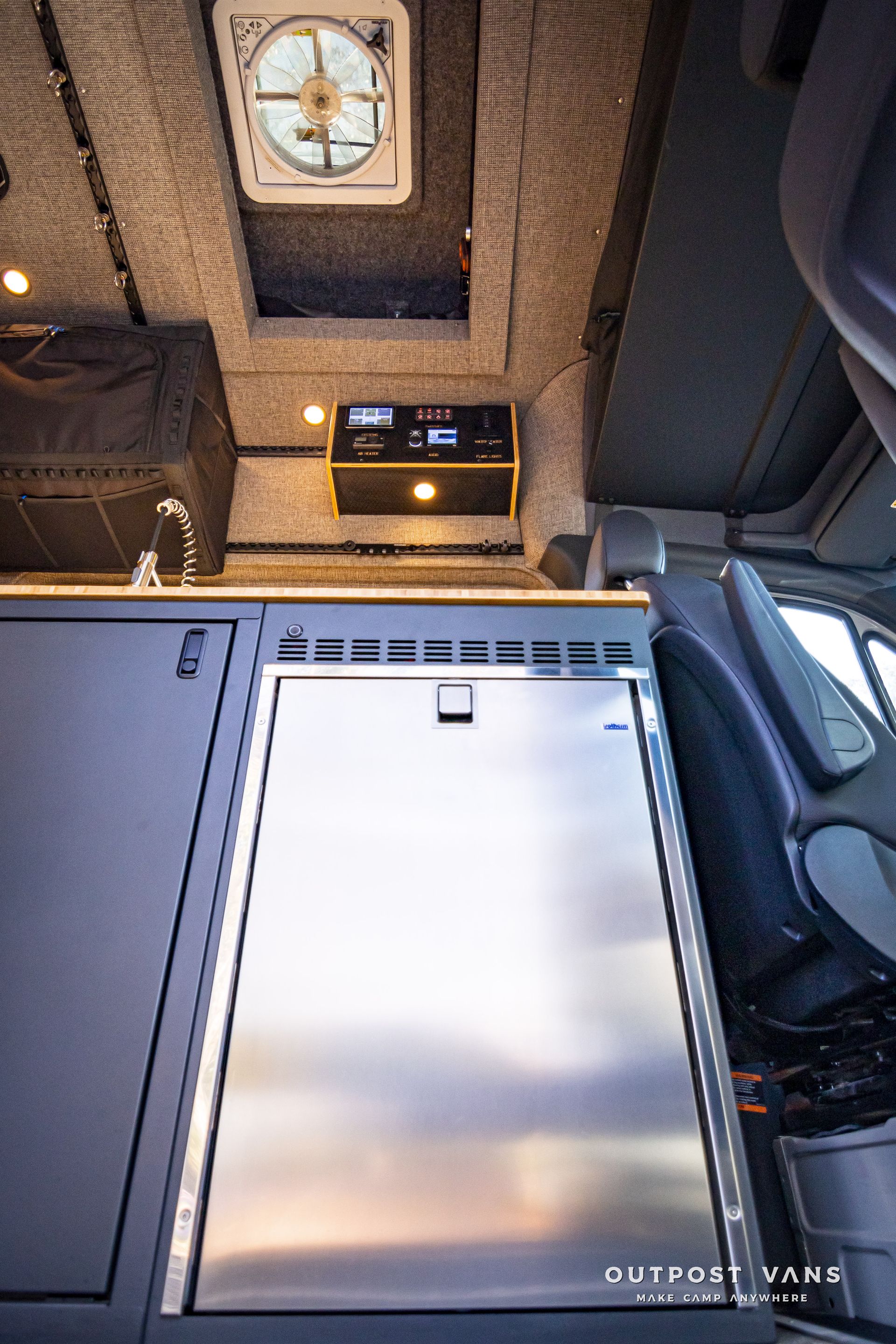 A stainless steel refrigerator is sitting in the back of a van.