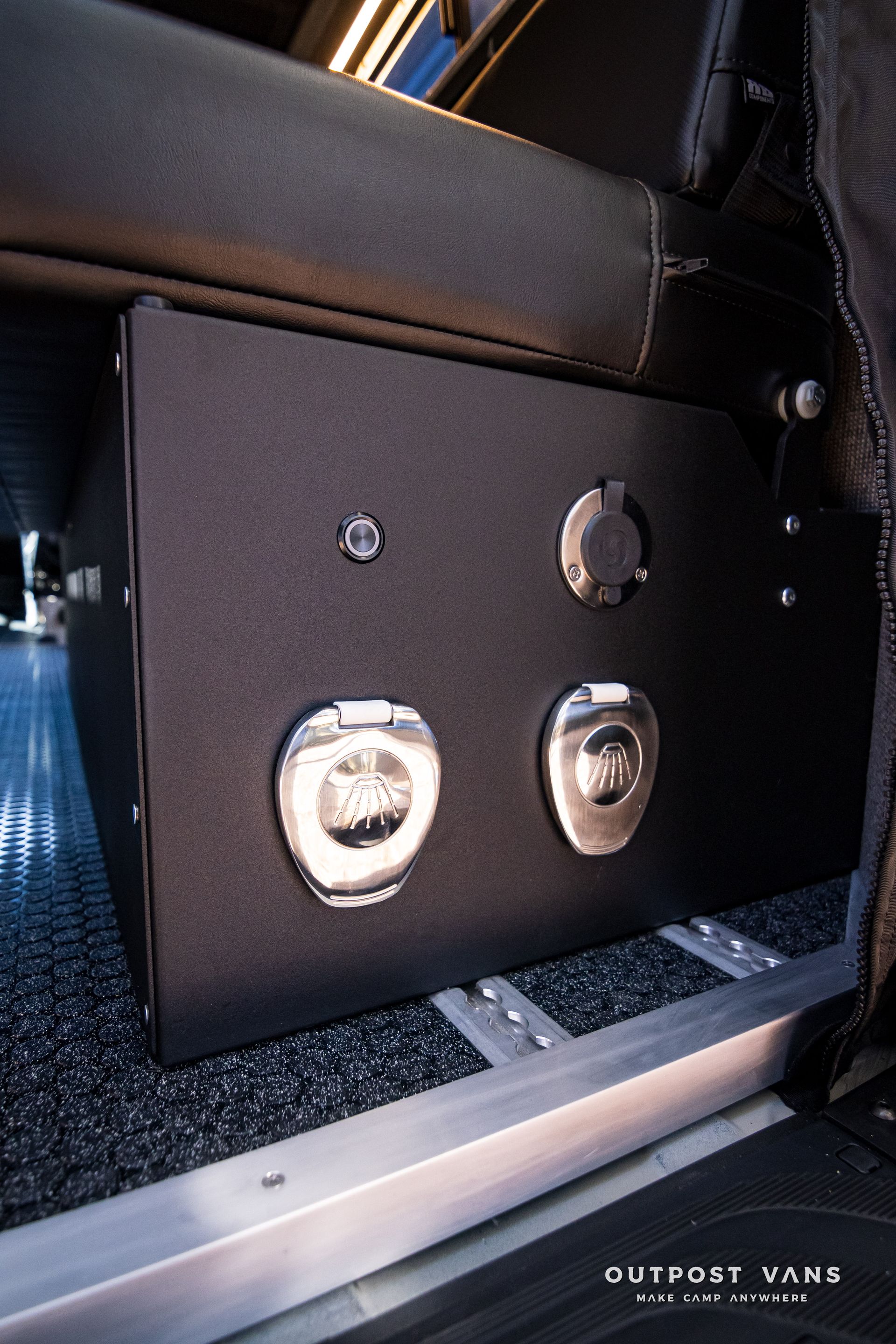 A black box with two outlets on the side of a van.
