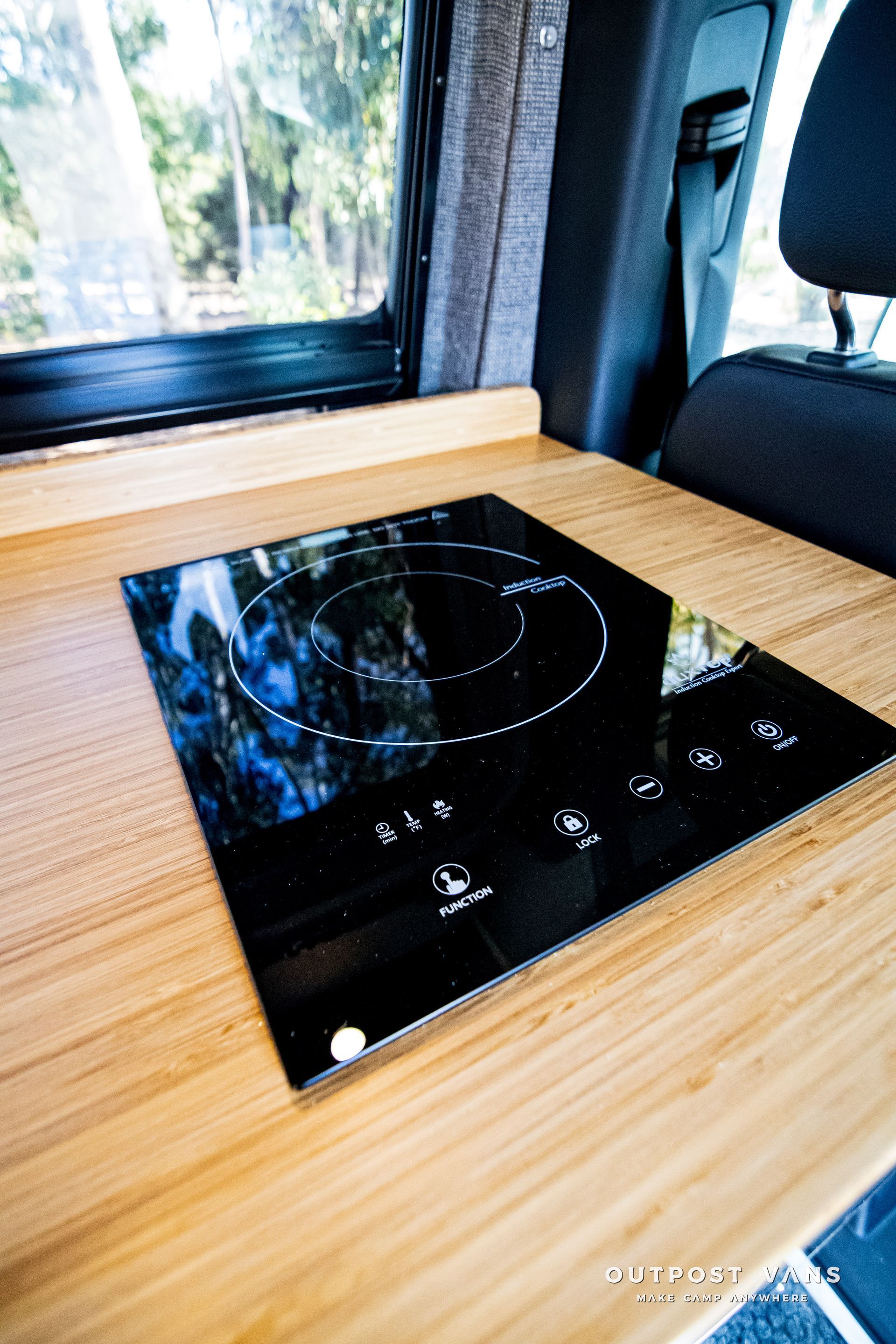 A small stove is sitting on top of a wooden table in a car.