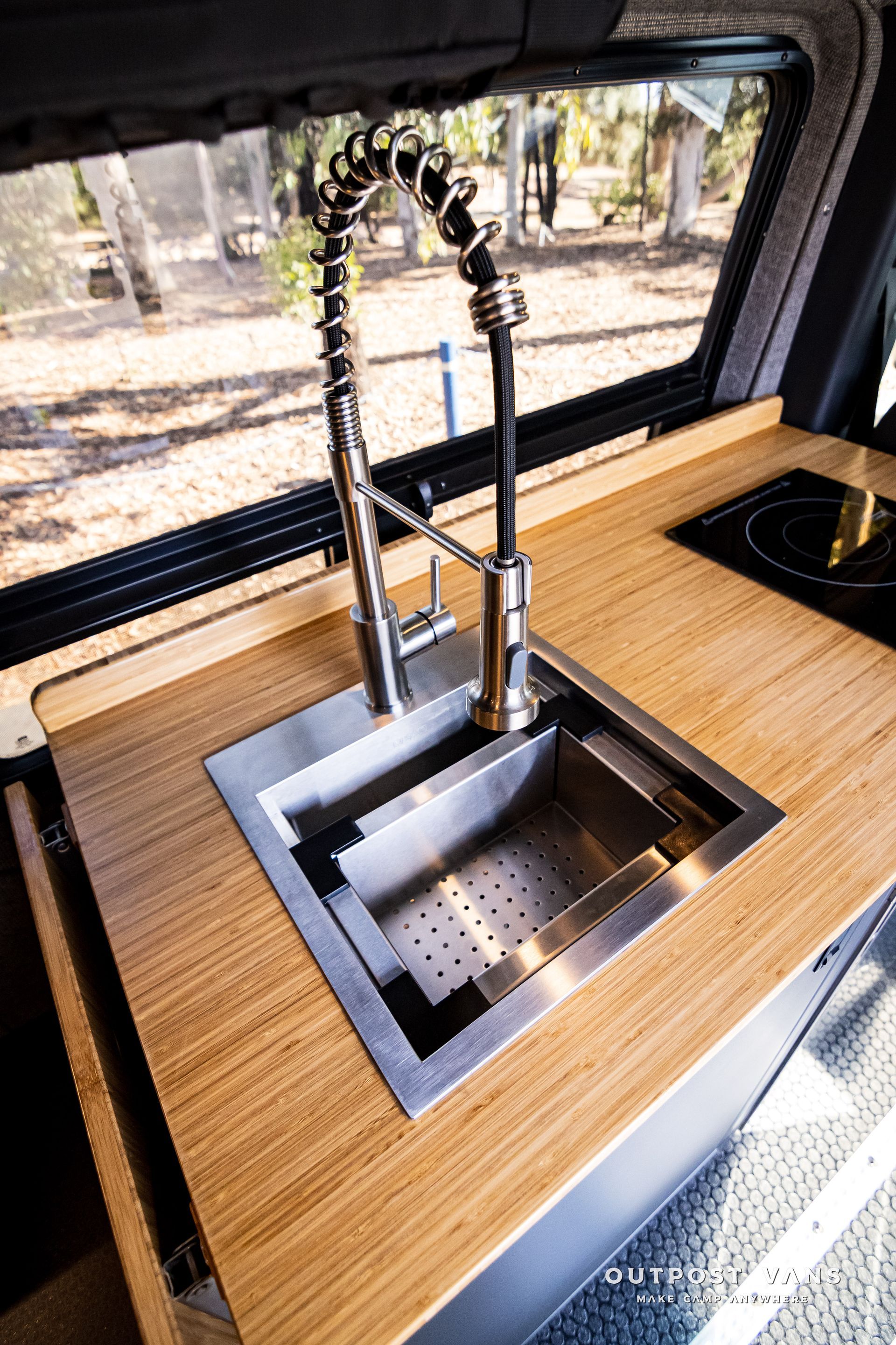 A stainless steel sink is sitting on top of a wooden counter.