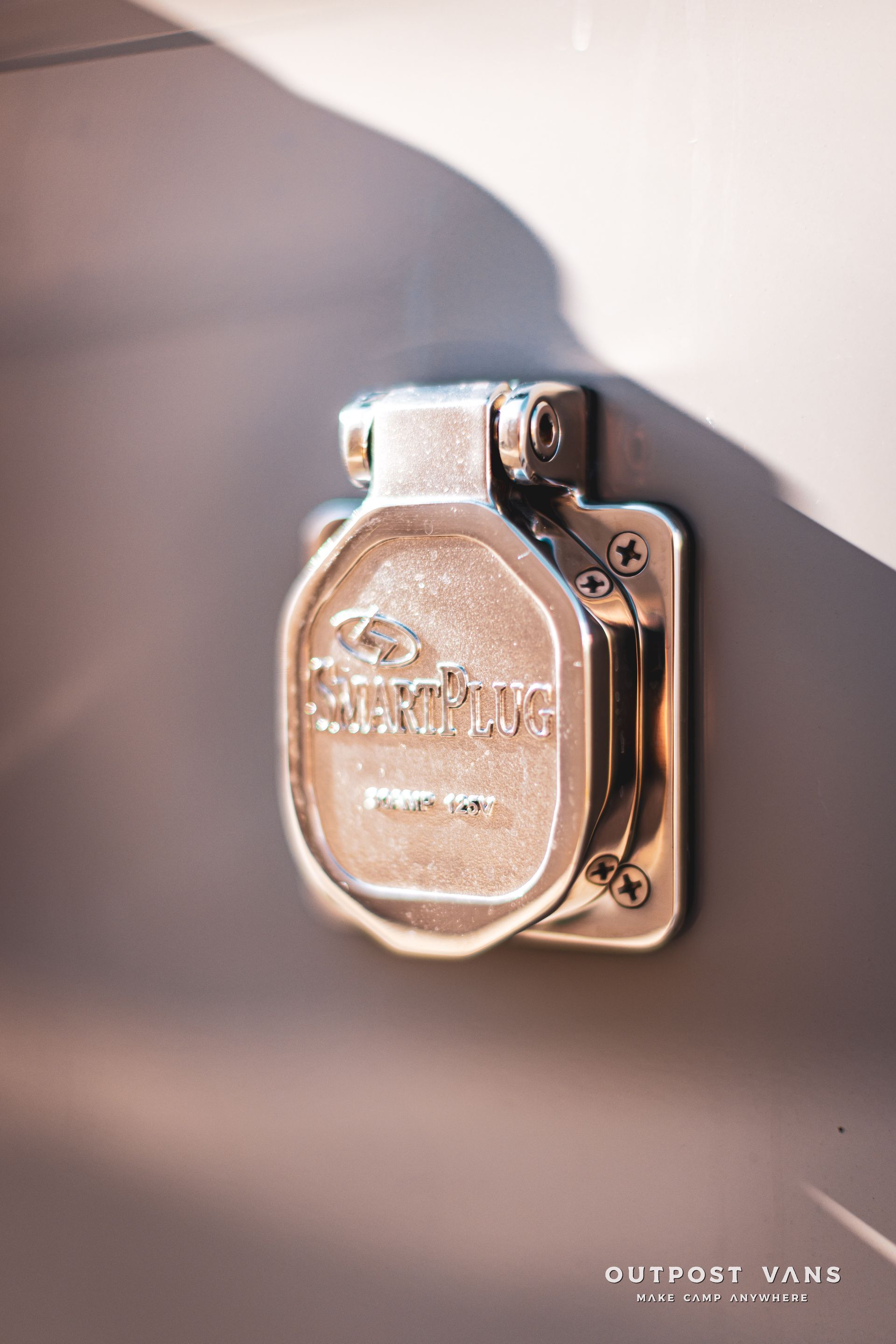 A close up of a metal electrical outlet on a wall.