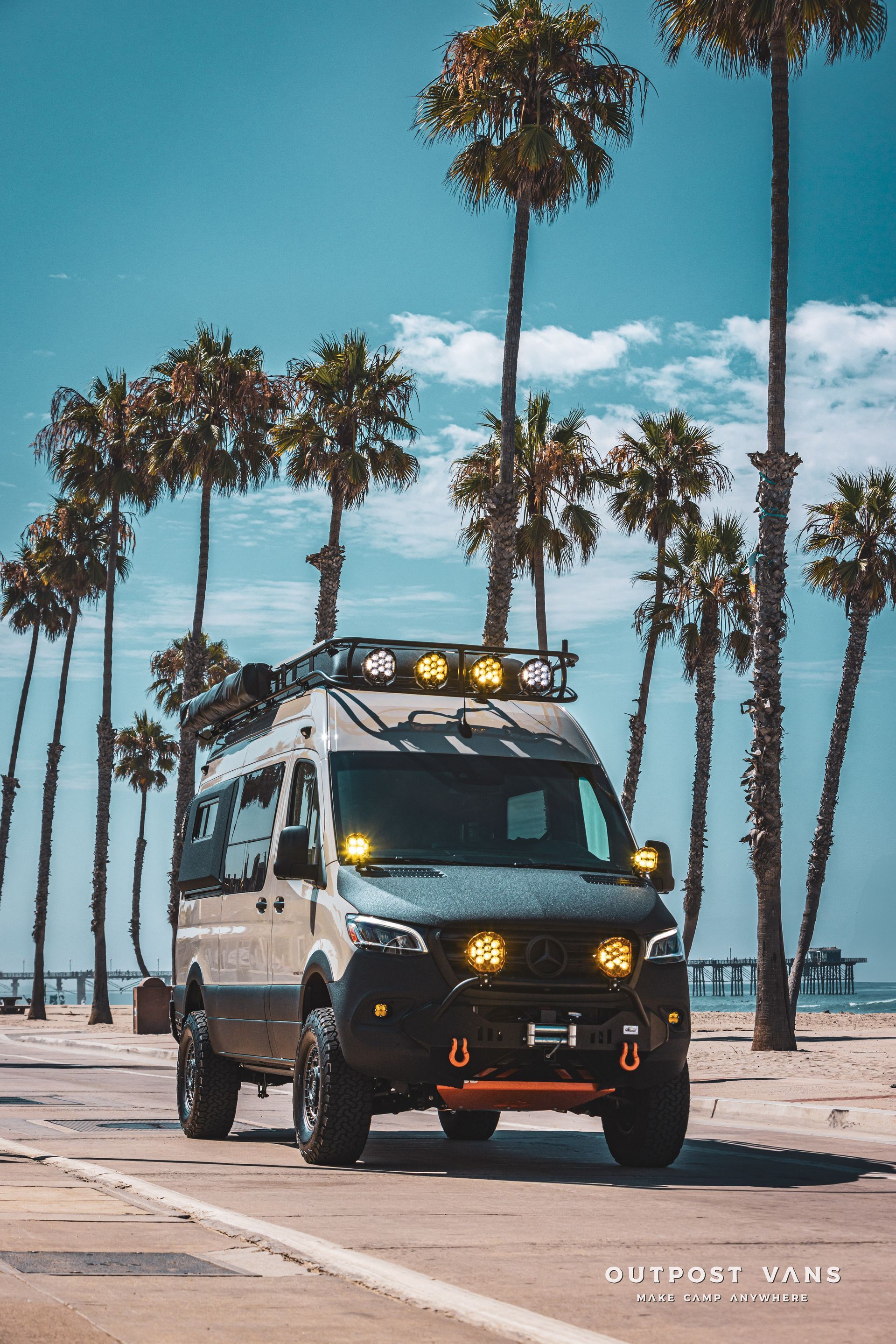 A van is driving down a road next to palm trees.