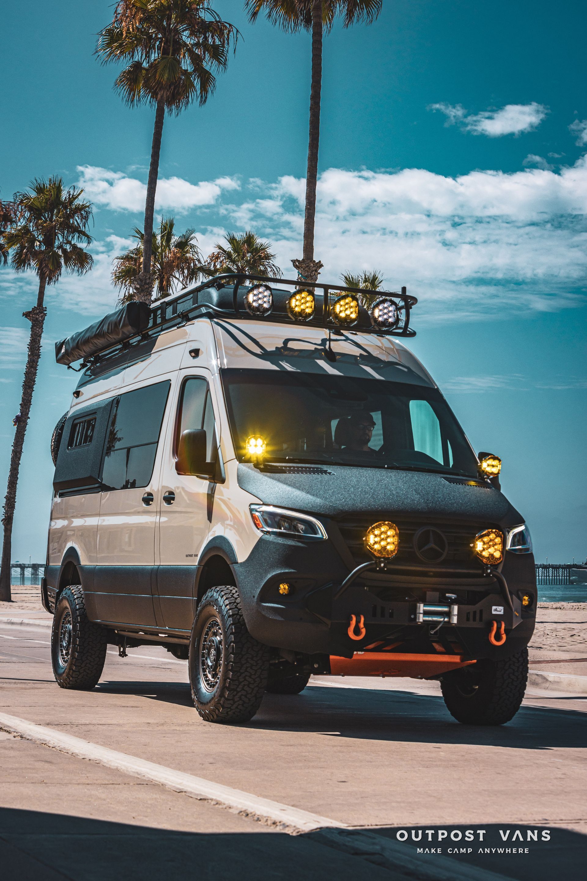 A van is parked on the side of the road next to a beach.