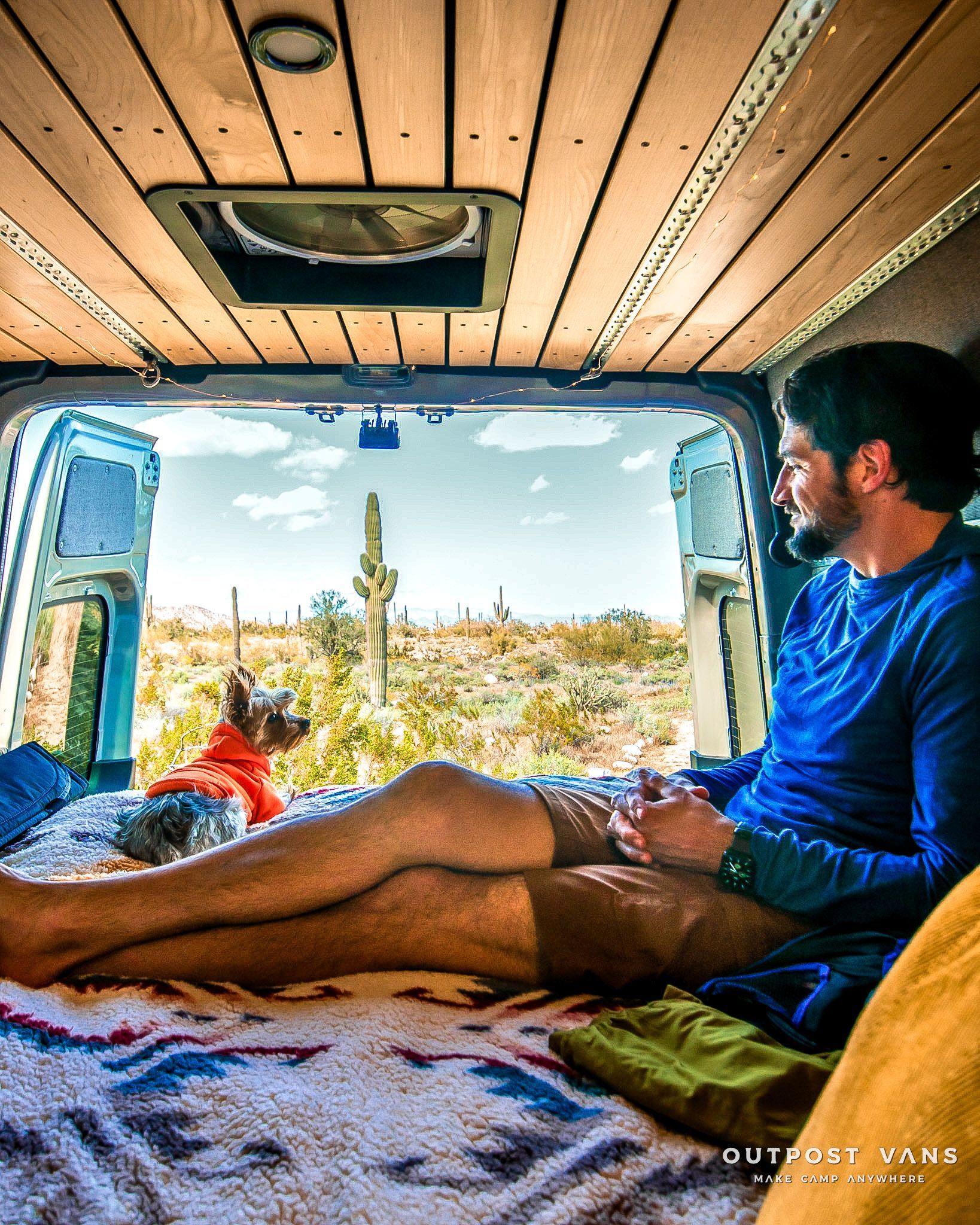 a man is sitting in the back of a van looking out the window .