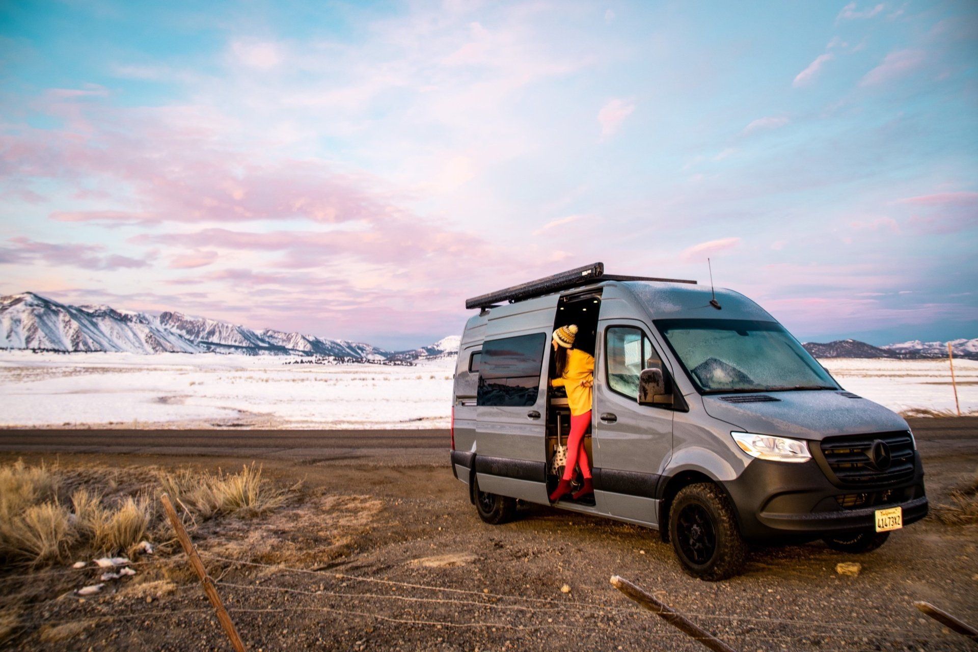 a man is getting out of a van on the side of the road .