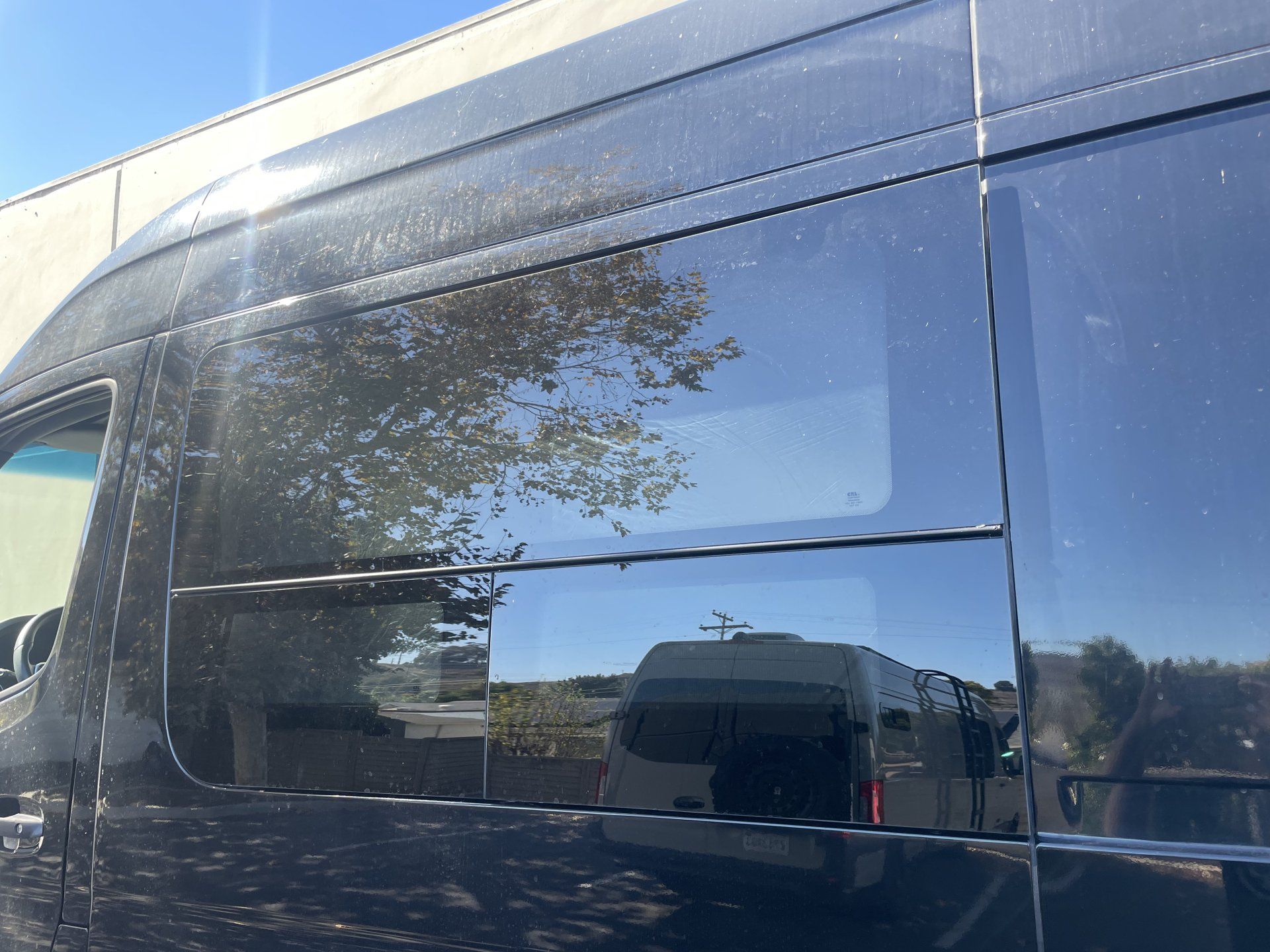 A black van is parked in front of a building.