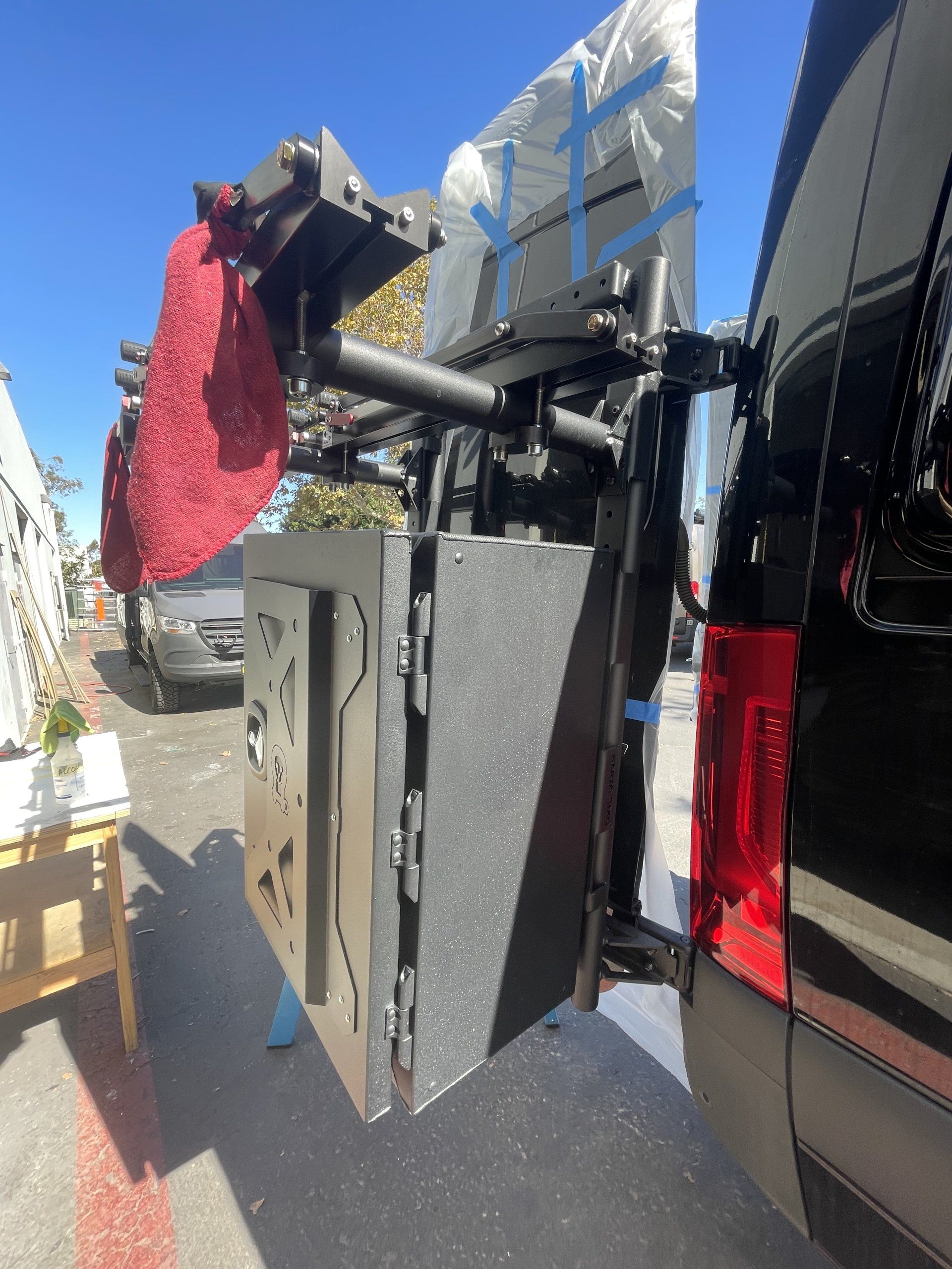 A red towel is hanging from the back of a van