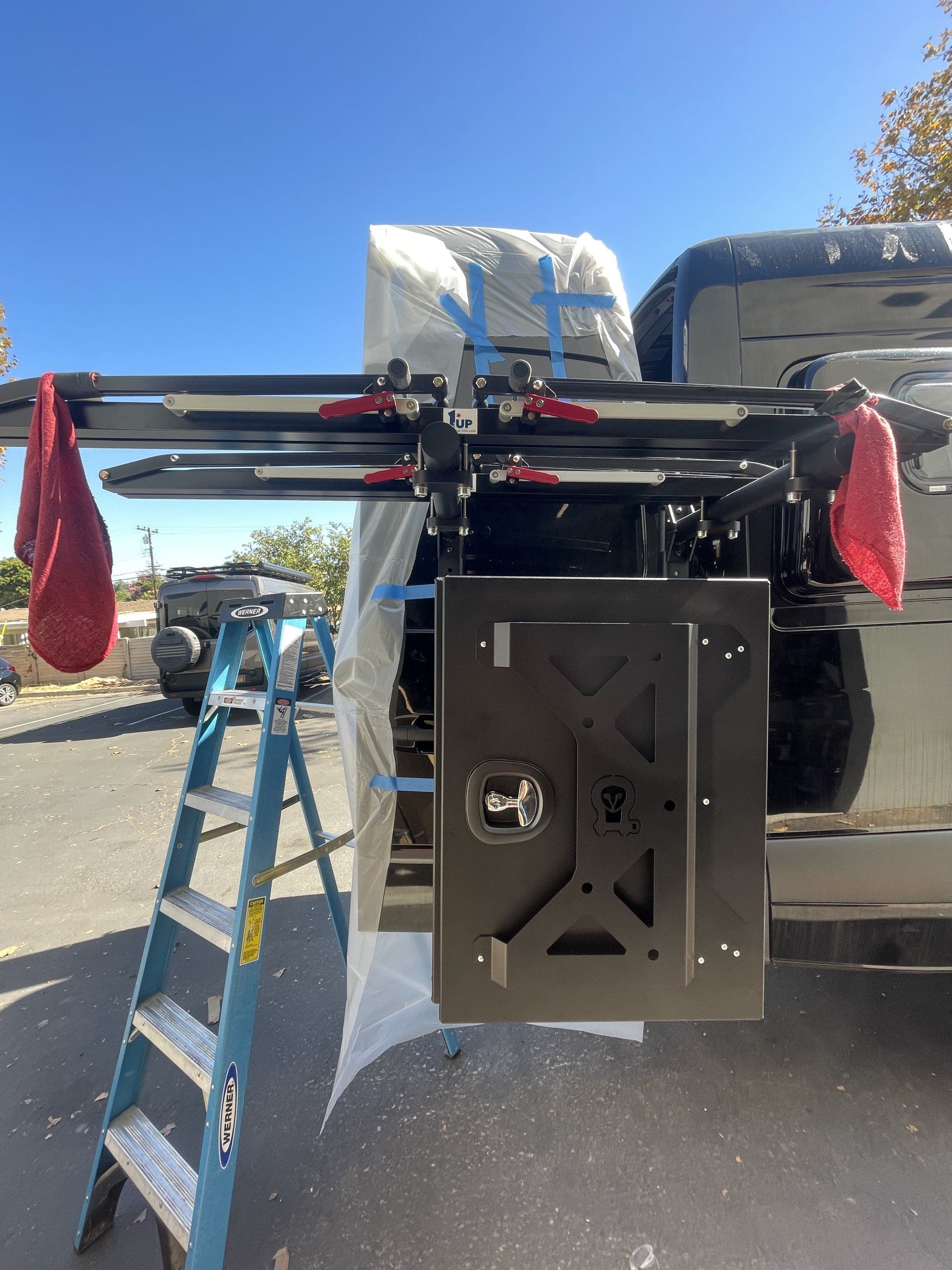 A ladder is attached to the back of a truck