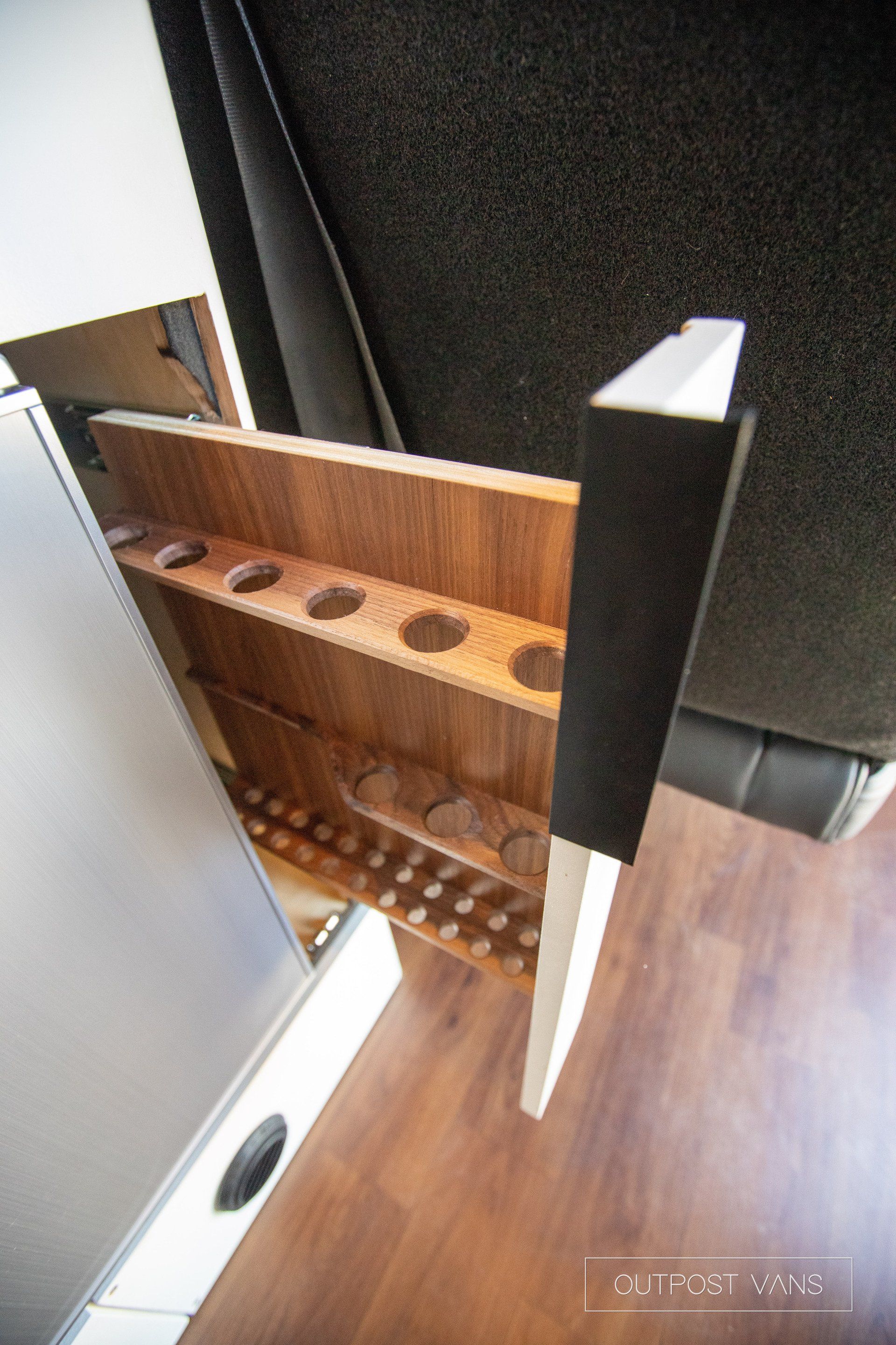 A wooden shelf with holes in it is in a room.