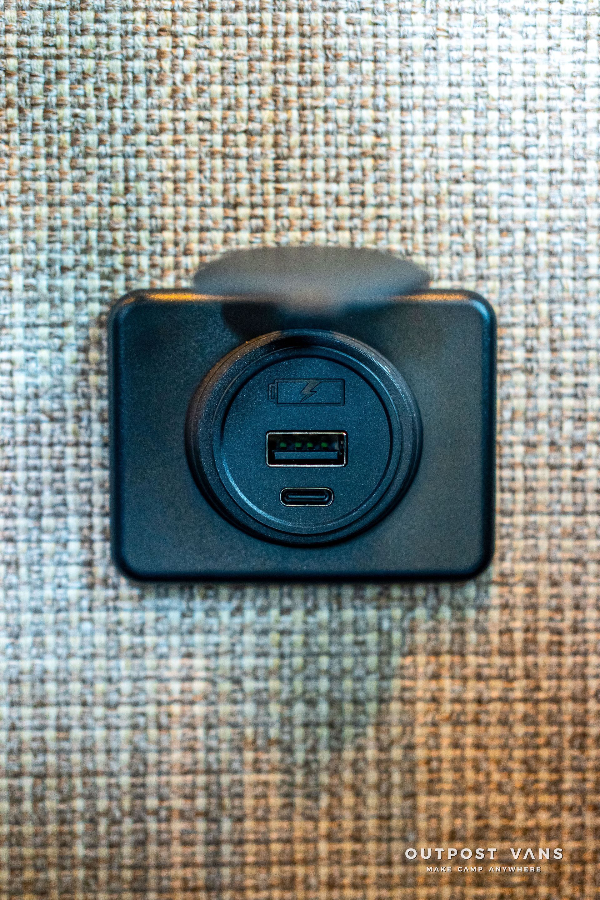 Black USB charger with 2 ports, mounted on a textured tan surface.