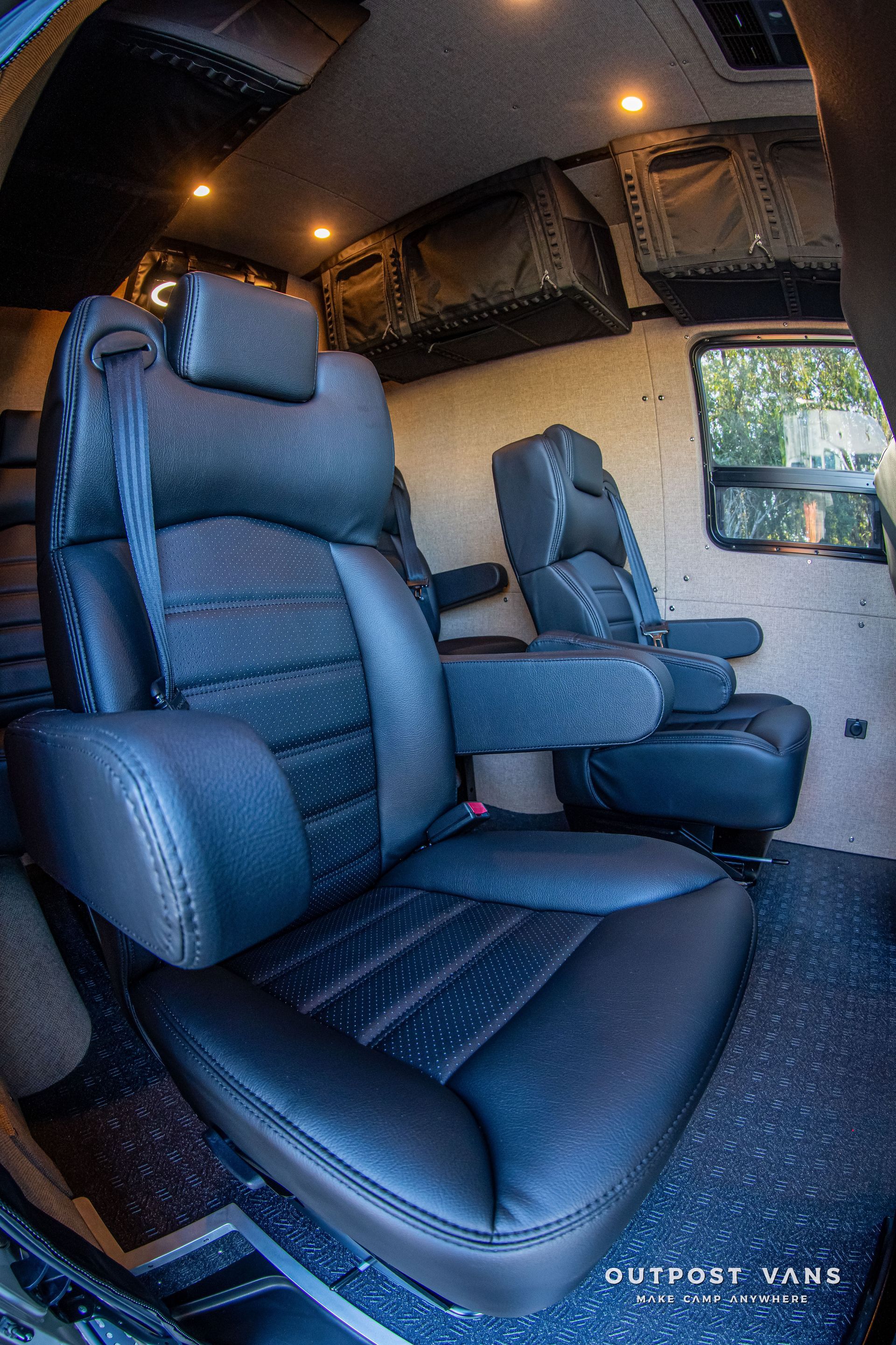 Black leather seats inside a van. Black overhead storage and window are visible.