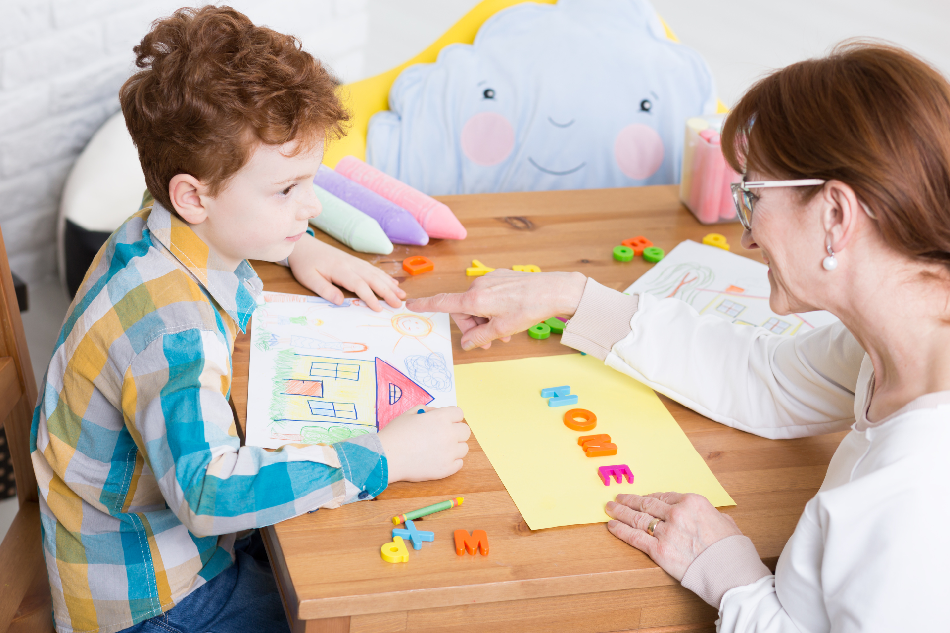 Adult and child playing a counting game at a table with colorful letters and cards