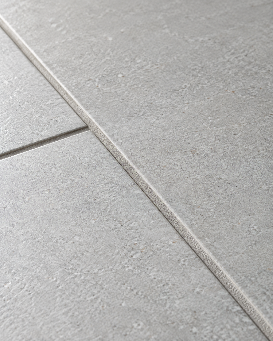 Close-up detail of sanitized ceramic floor tile and clean grout line.
