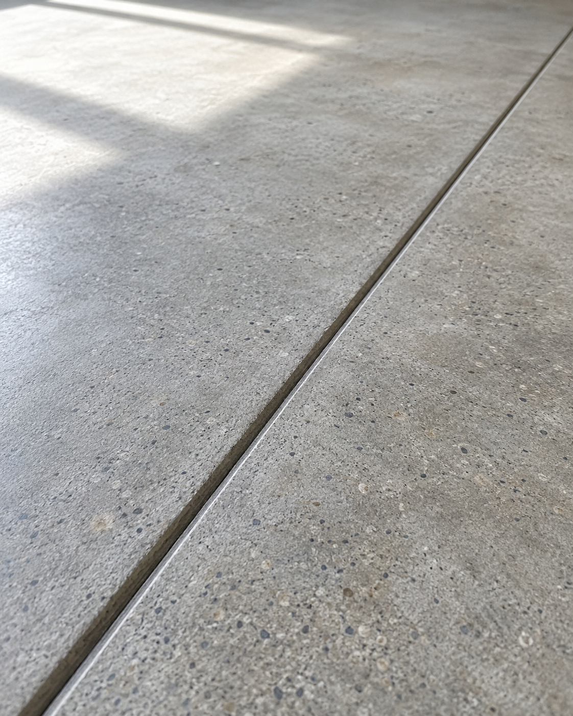 Close-up detail of a clean concrete subfloor surface and expansion joint line.