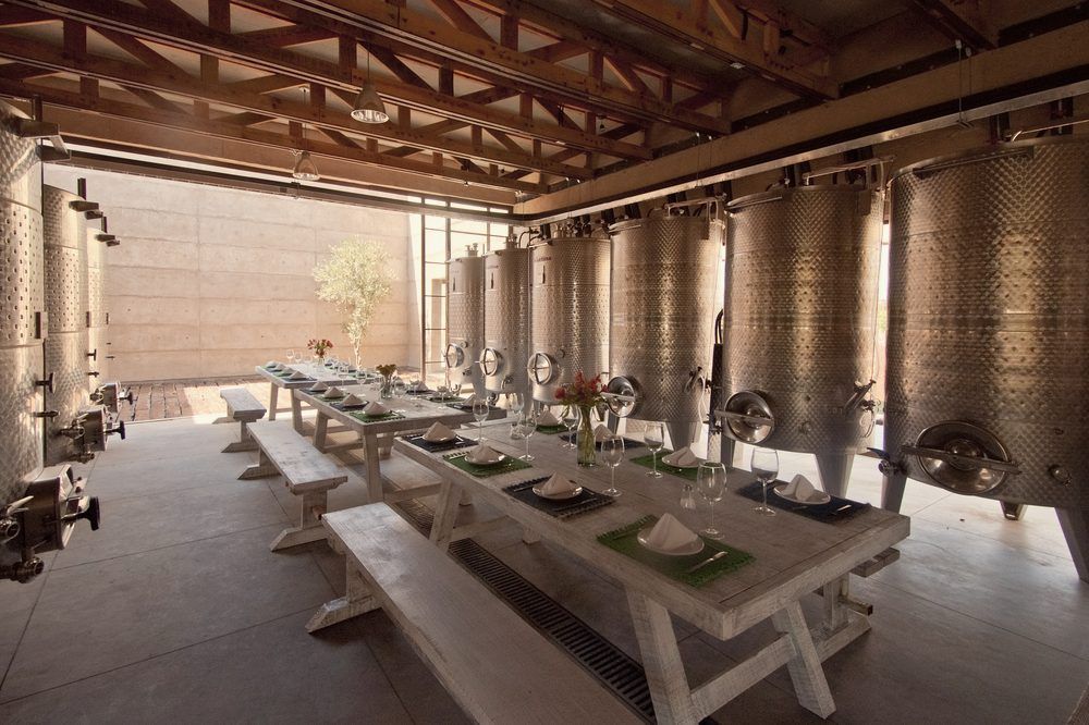 Banquete montado entre los tanques de acero de la bodega