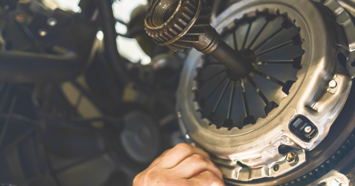 Car clutch assembly being worked on by a person's hand.