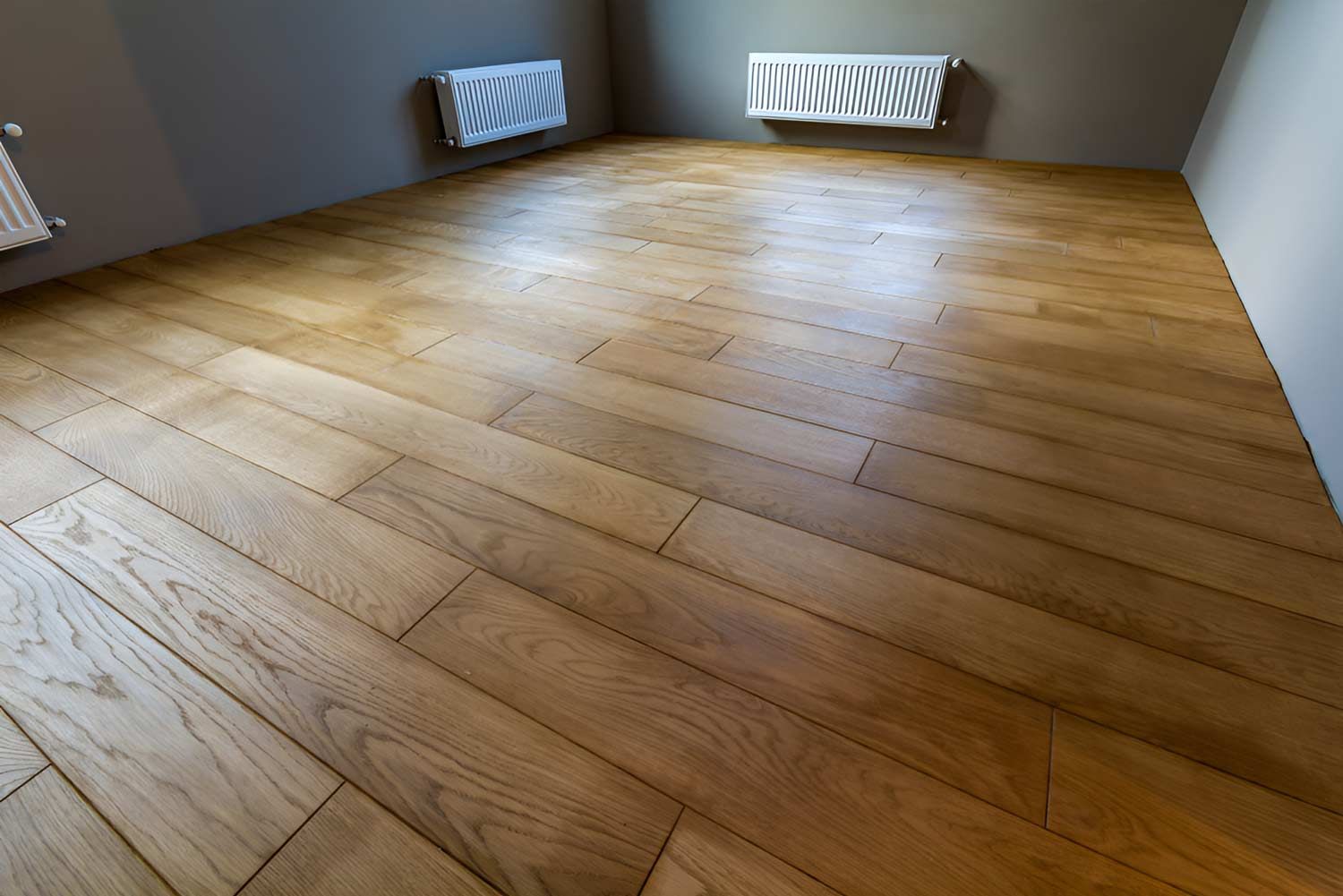 A Room With A Wooden Floor And Two Radiators On The Wall — Flooring Direct Mid North Coast in South Kempsey, NSW