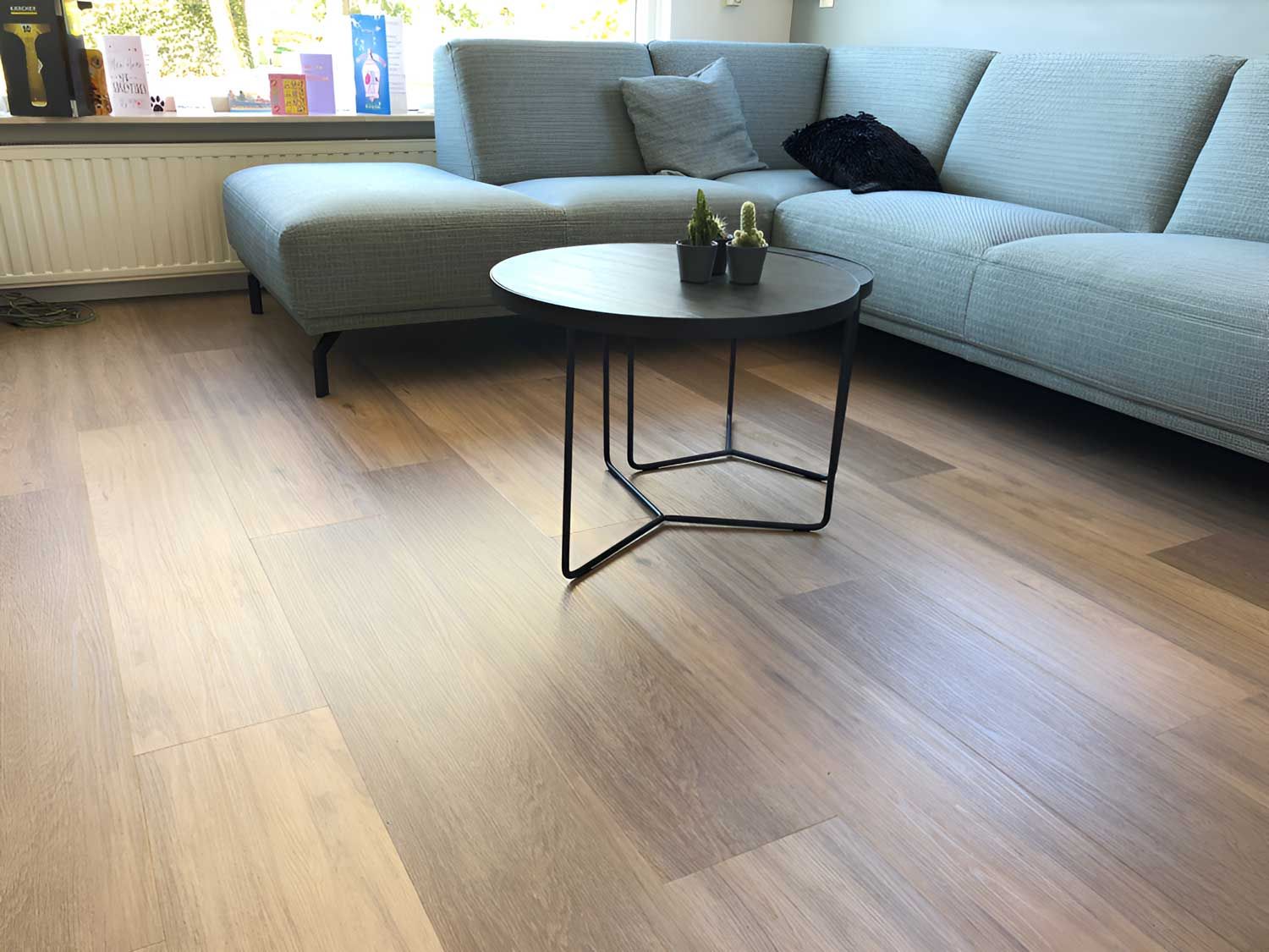 A Living Room With A Couch And A Coffee Table With Vinyl Flooring — Flooring Direct Mid North Coast in  Kempsey, NSW