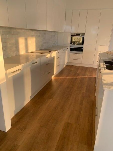 A Kitchen With White Cabinets And Wooden Floors — Flooring Direct Mid North Coast in South Kempsey, NSW