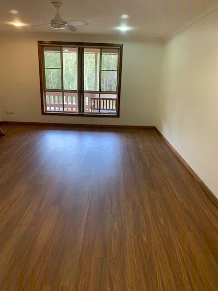 An Empty Living Room With Hardwood Floors And A Ceiling Fan — Flooring Direct Mid North Coast in South Kempsey, NSW