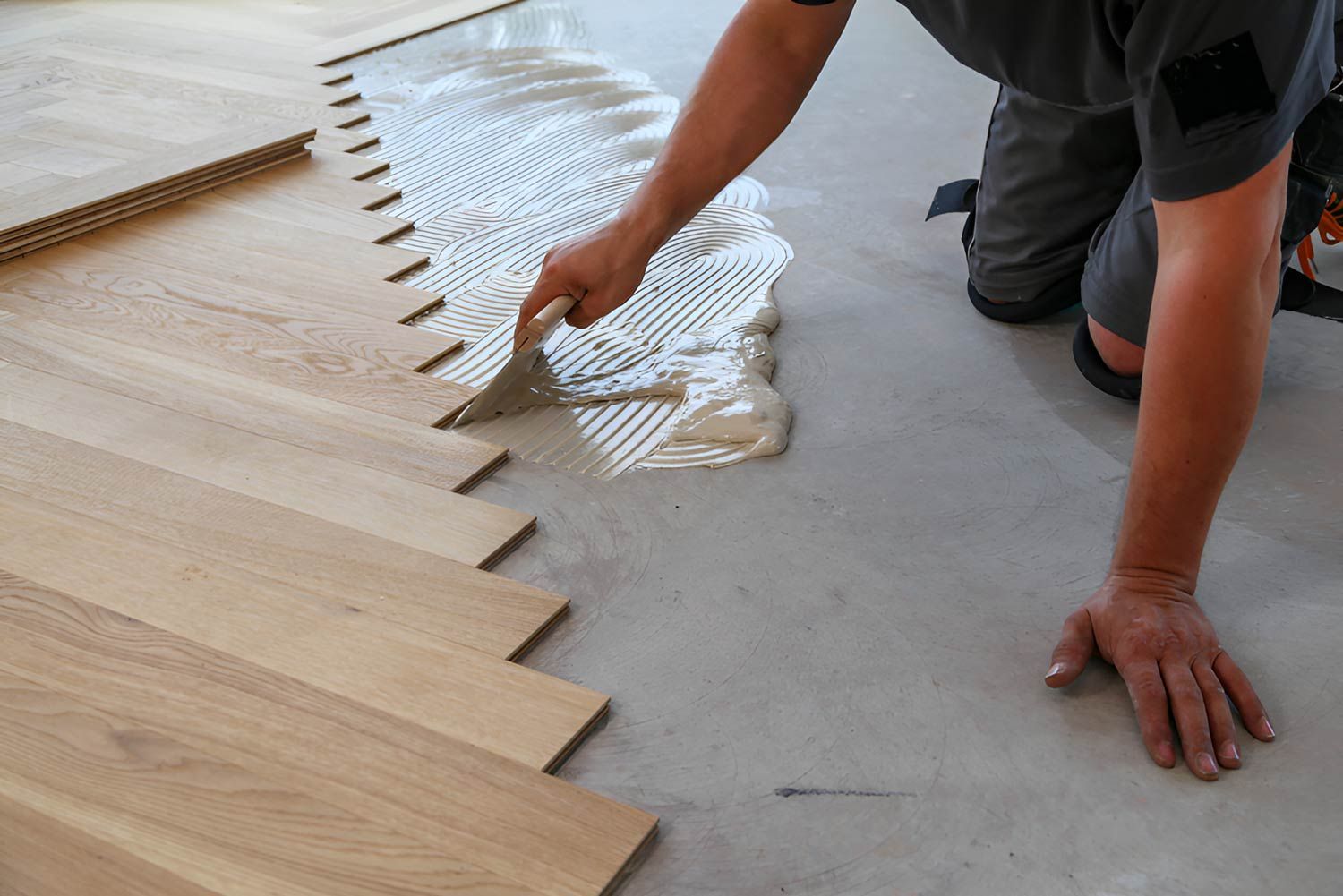 Worker Installing Wooden Laminate Flooring — Flooring Direct Mid North Coast in South Kempsey, NSW