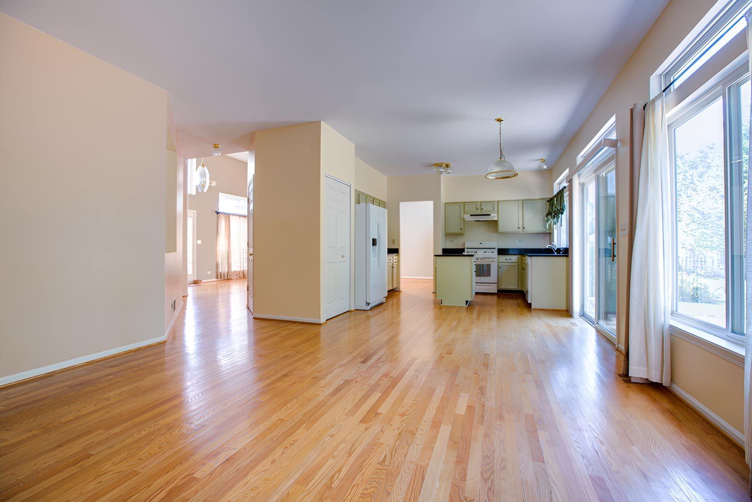 An Open, Empty Space With A Kitchen And Wooden Floors — Flooring Direct Mid North Coast in  Frederickton, NSW