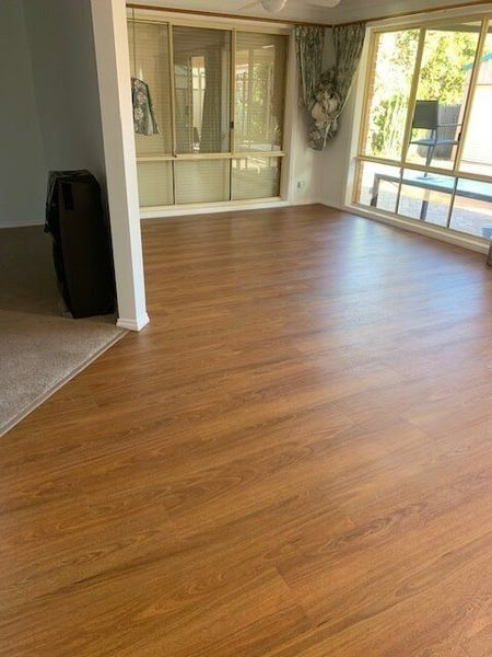 A Living Room With A Wooden Floor And Sliding Glass Doors — Flooring Direct Mid North Coast in South Kempsey, NSW