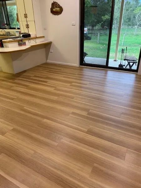 A Living Room With A Wooden Floor And A Sliding Glass Door — Flooring Direct Mid North Coast in South Kempsey, NSW
