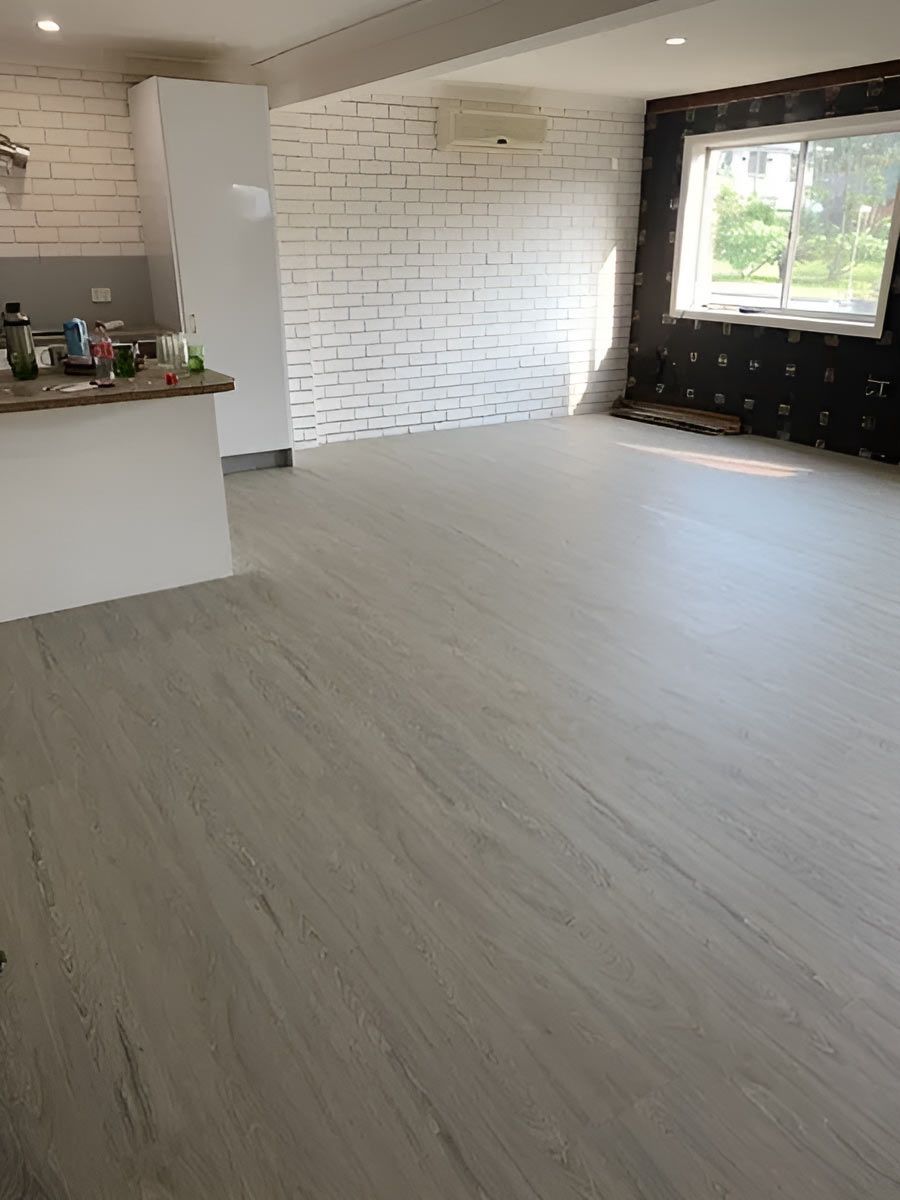A Living Room With A vinyl Flooring And A Brick Wall — Flooring Direct Mid North Coast in South Kempsey, NSW