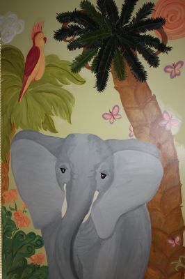 Gray elephant under palm trees with butterflies, beside a red parrot on leafy jungle background