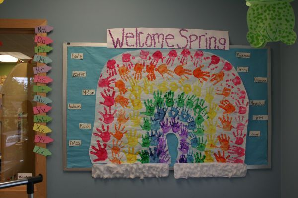 Colorful “Welcome Spring” classroom bulletin board with rainbow handprints and paper flowers