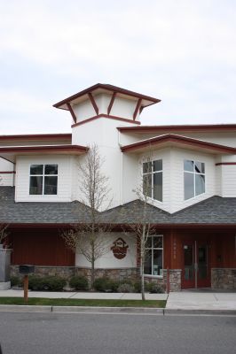 Front view of a white and red building with large windows and a small tower-like roof.