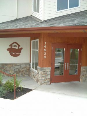 Entrance to a building with wood doors, stone accents, and the number 14928 on the pillar