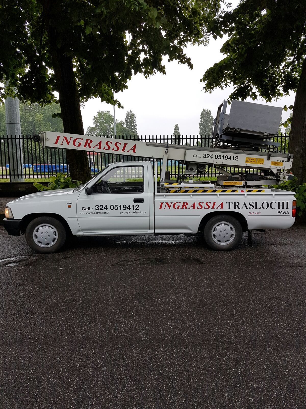 Pickup bianco con scritta INGRASSIA TRASLOCHI e prolunga per il sollevamento.