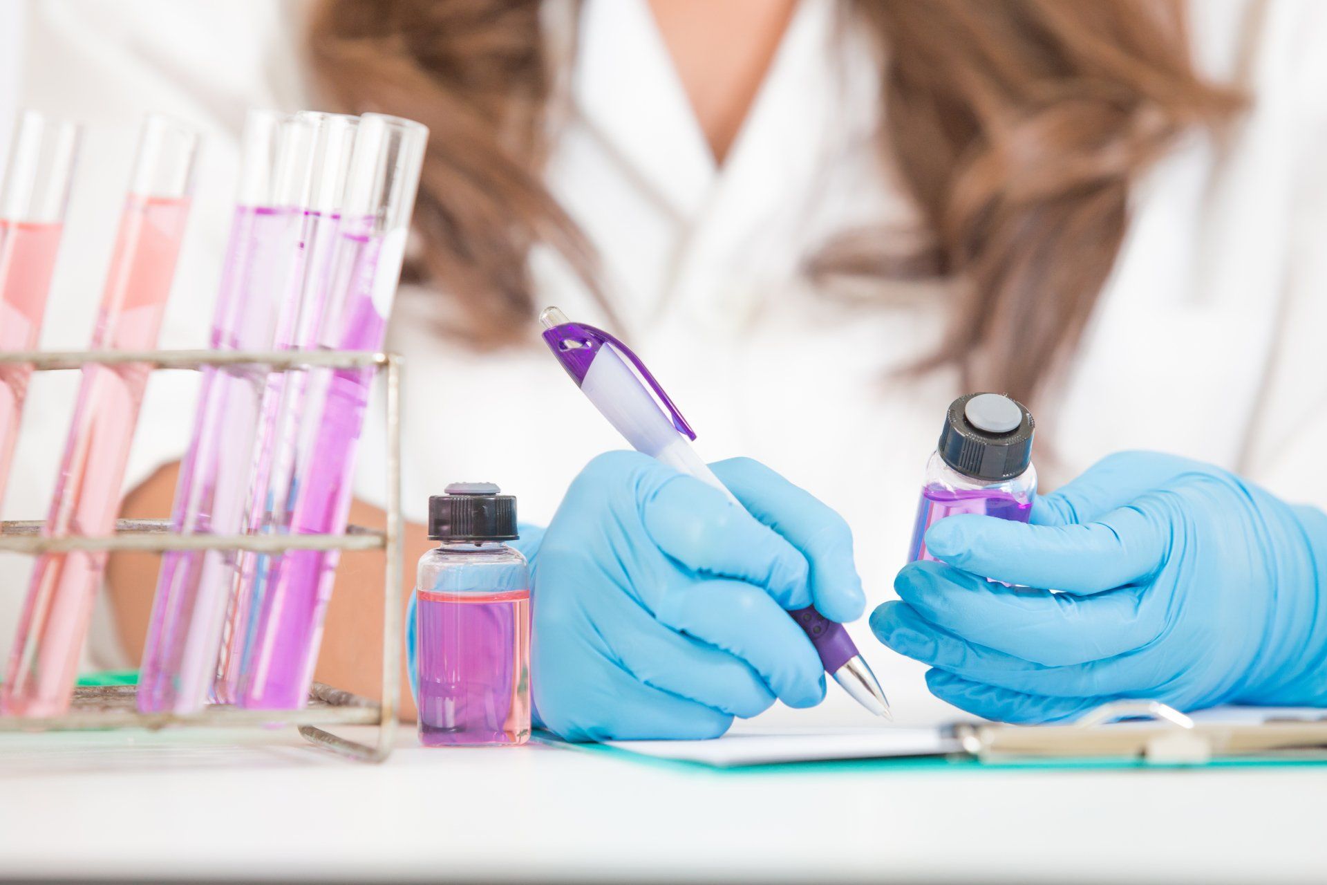 Scientist holding a pen and a test jar