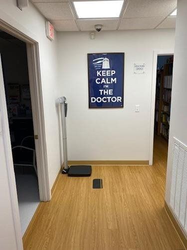 Hallway with a blue “KEEP CALM AND ASK THE DOCTOR” sign on the wall.