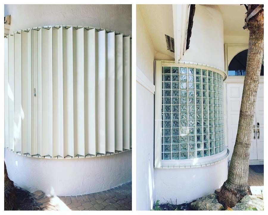 Curved white wall with vertical slats beside a glass block window and a tree trunk