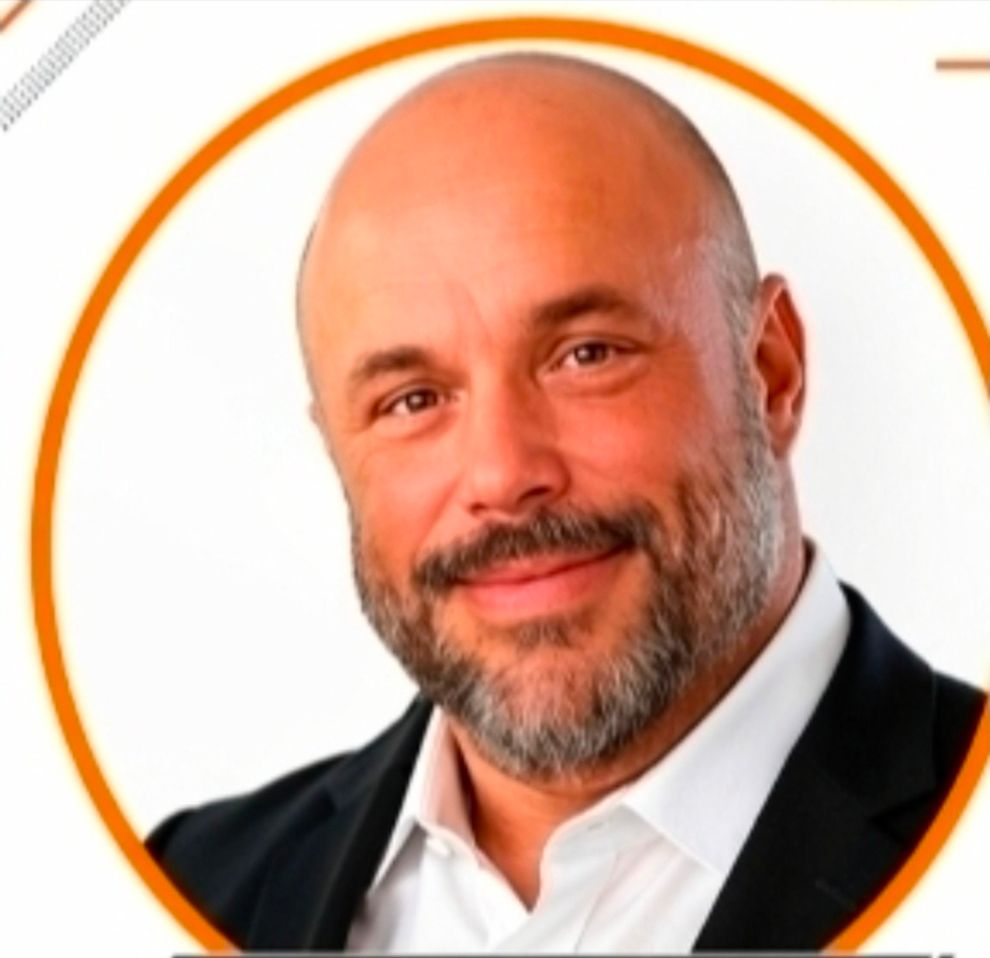 A bald man with a beard is smiling for the camera.