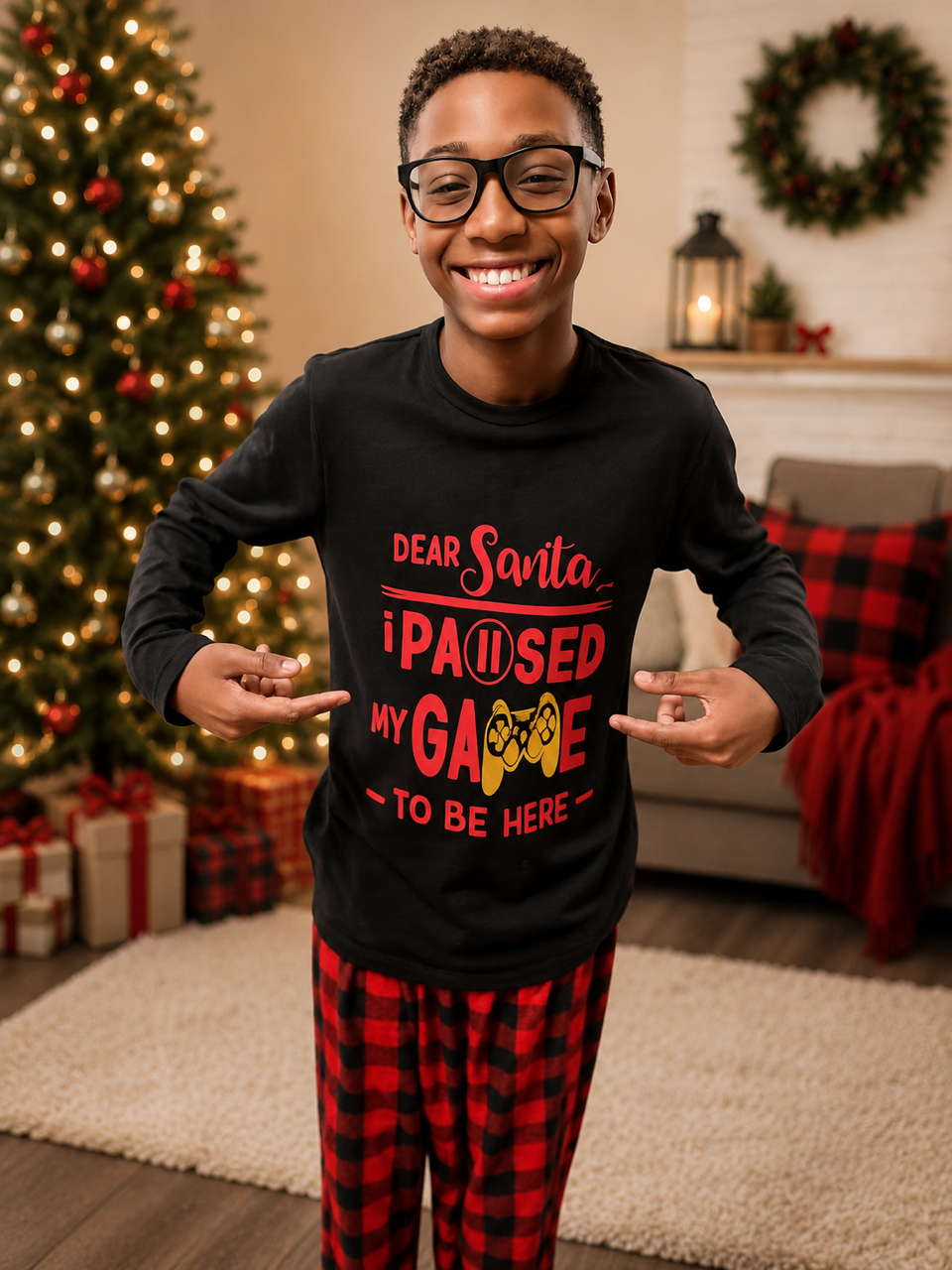 Boy in festive pajamas smiling in a holiday living room, holding a sign that says he paused a game to be here.