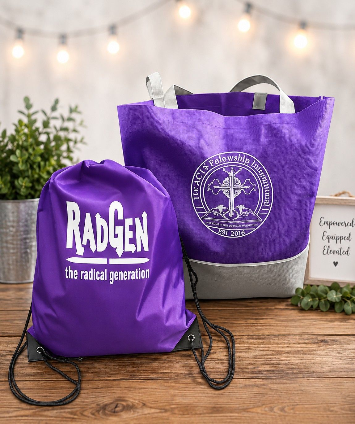 Purple RADGEN drawstring bag and tote bag on a wooden table with string lights in the background