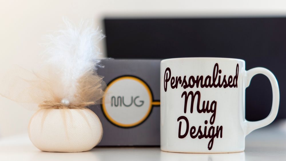 Personalised mug beside a black box and small white vase with pampas grass