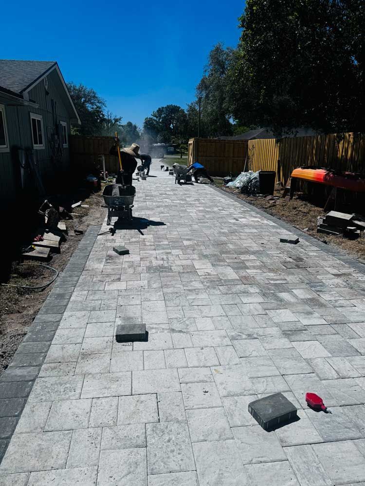 A brick walkway is being built on a sunny day.