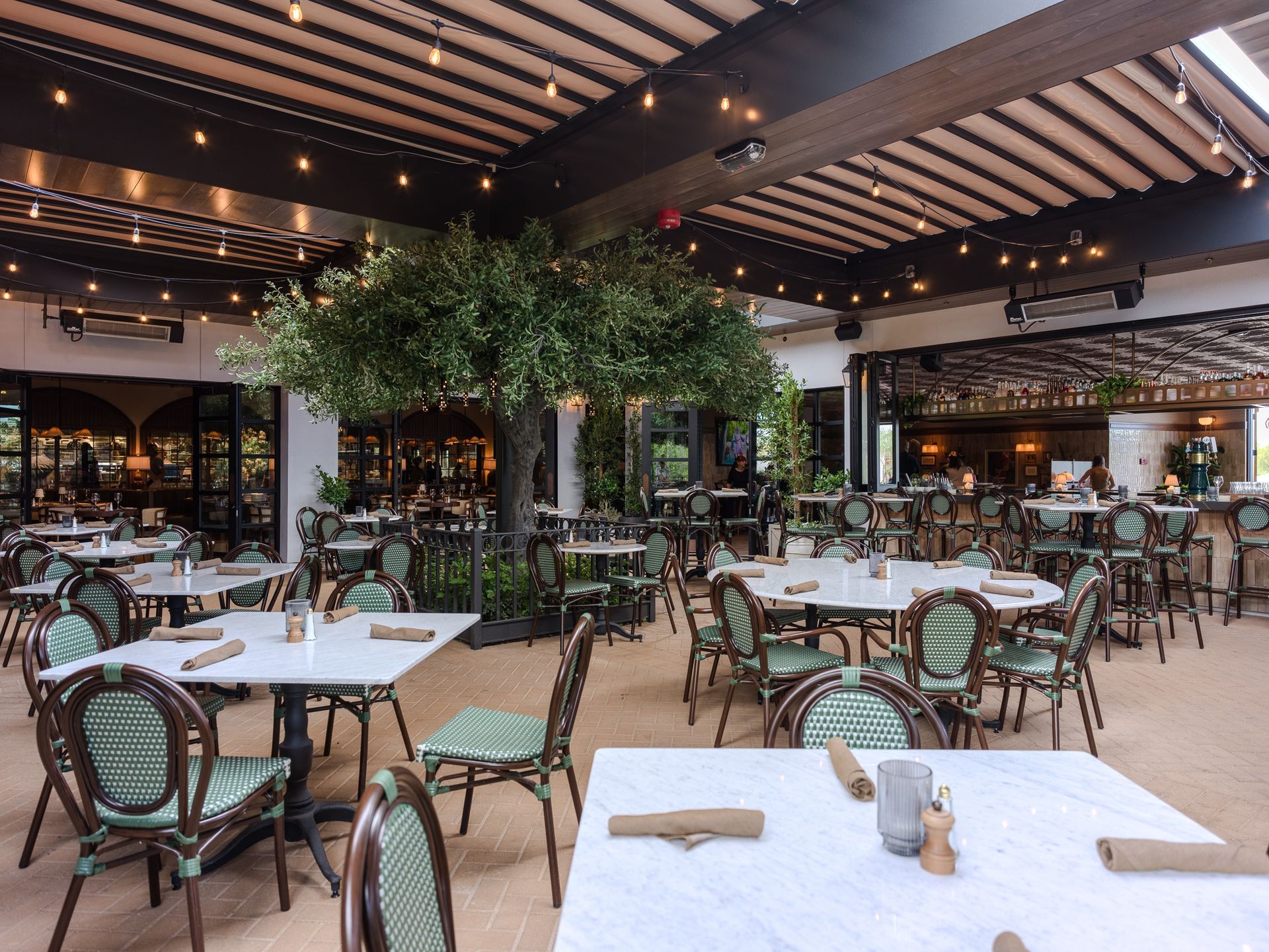 A restaurant with tables and chairs set for a dinner party.