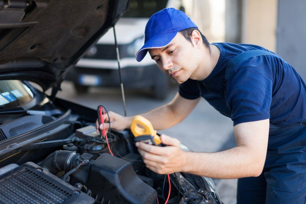 A Man is Working on a Car With the Hood Open — SVS Auto Repairs & Dyno Tuning in Bungalow, QLD