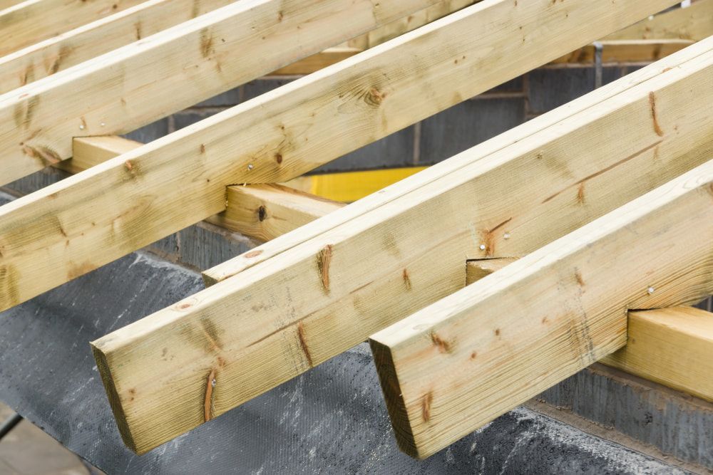 A Bunch Of Wooden Beams Are Stacked On Top Of Each Other — Hitek Frame & Truss In Brewarrina, NSW