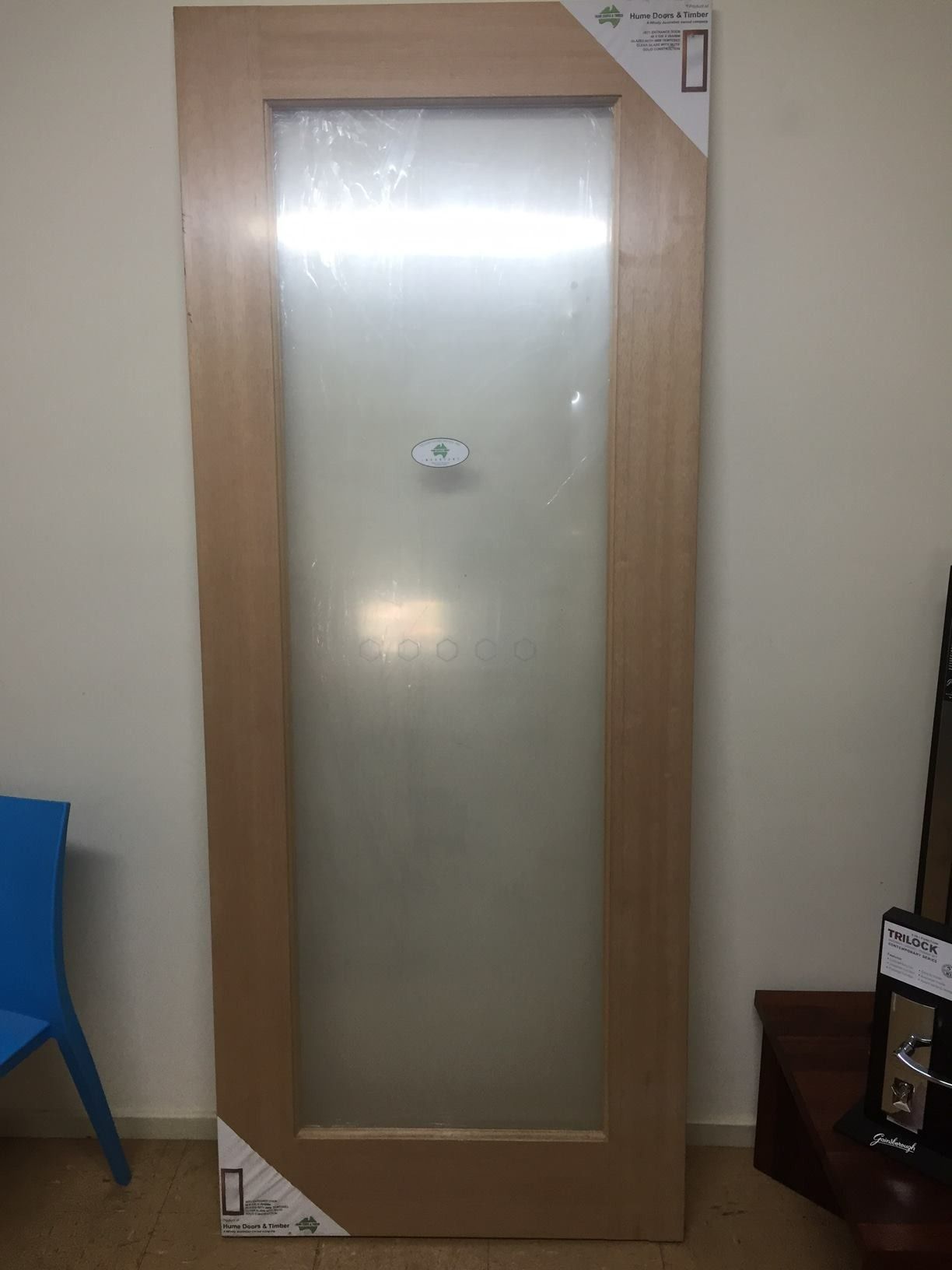 A Wooden Door With A Clear Glass Panel Is Sitting In A Room — Hitek Frame & Truss In Dubbo, NSW