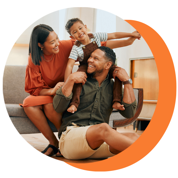 A man is sitting on the floor holding a child on his shoulders.